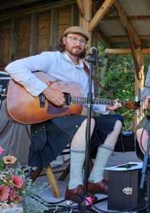 Man playing guitar dressed in kilt